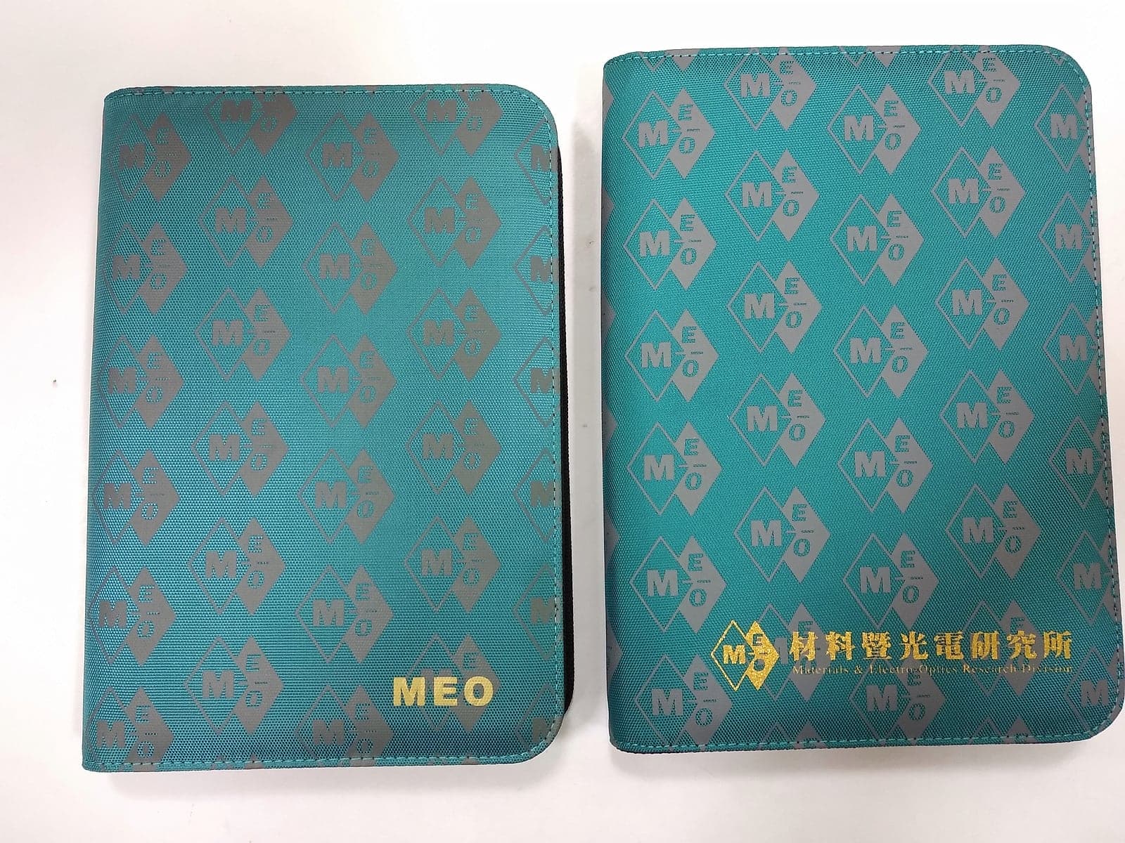 青綠滿版菱格織紋書衣兩款尺寸並列,封面燙金字樣